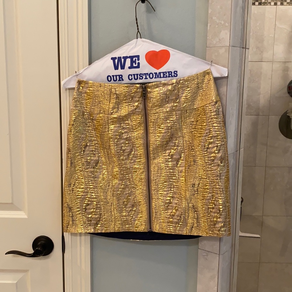Short, gold, lined skirt.